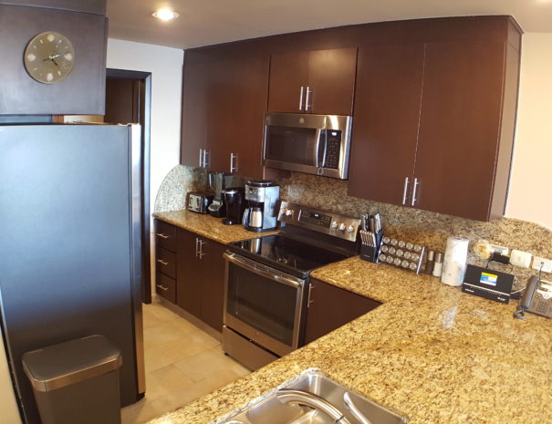 Full kitchen with granite counter tops and stainless steel appliances.